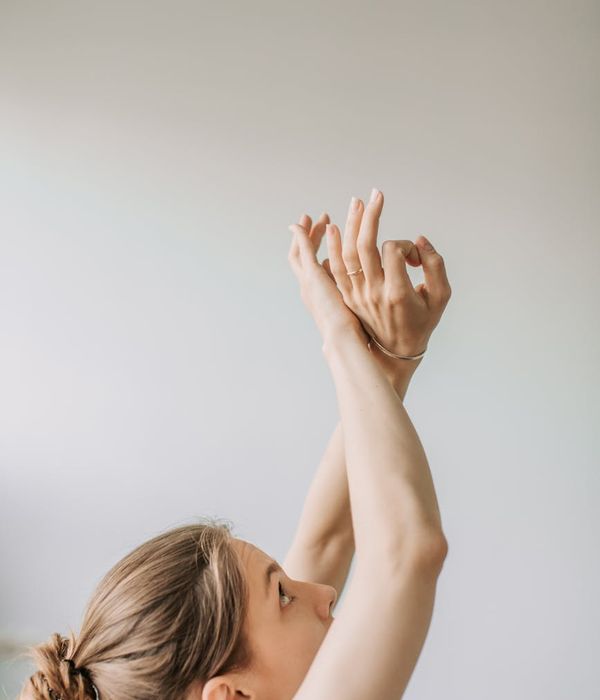 Woman peacefully practices a focus exercise, looking at her finger with a calm background.
